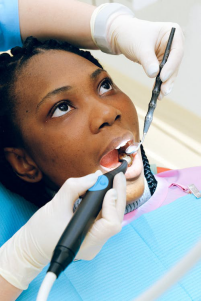 A woman receiving a dental check-up in a clinic.